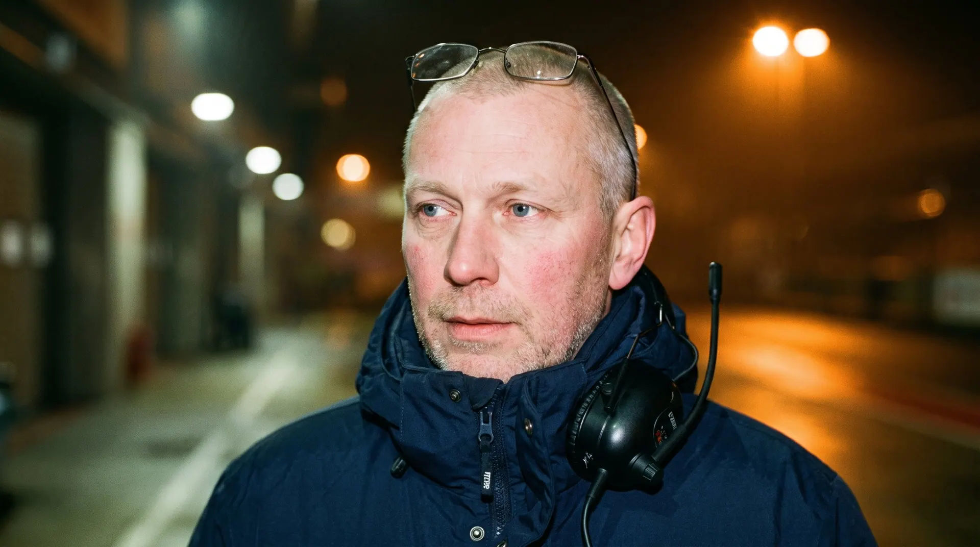 Henrik Sand at night in the paddock, headset round his neck